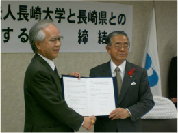 握手を交わす片峰学長（左）と金子知事