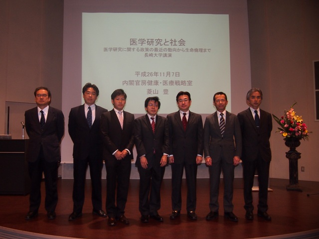 左から,森田熱研所長,西田副学部長,司会を務めた松藤寛さん,(医学部4年生),菱山氏,下川医学部長,永安副学部長,永山原研所長