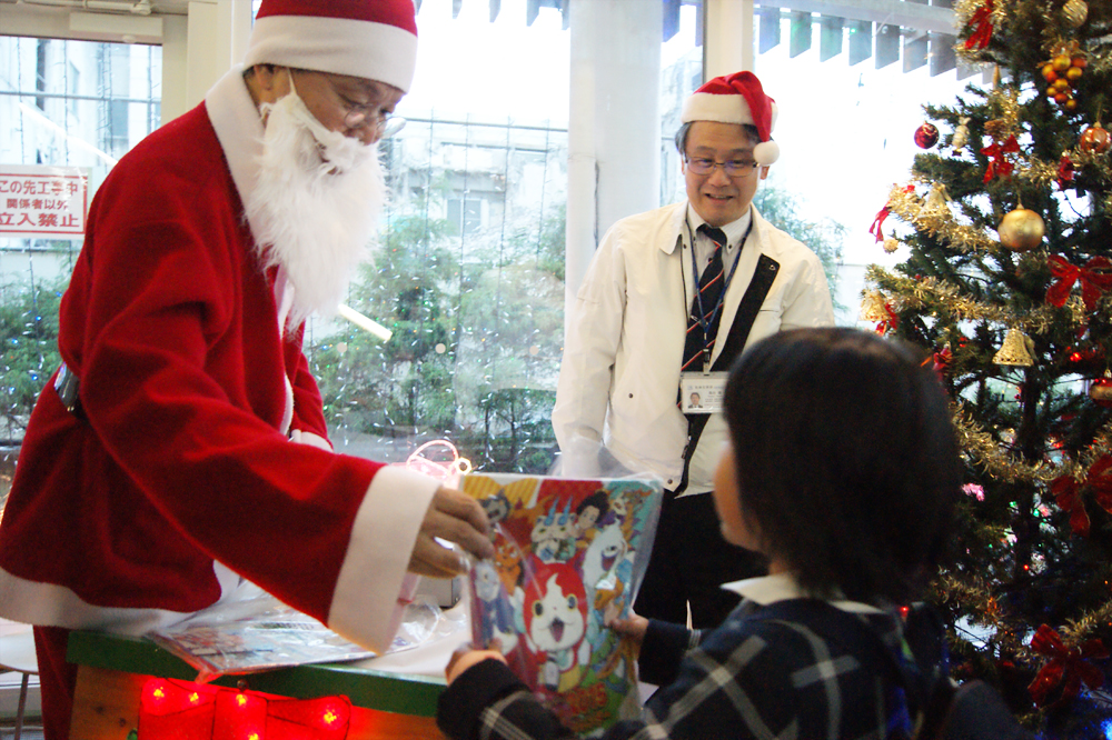 子どもたちにプレゼントを渡す病院長サンタ