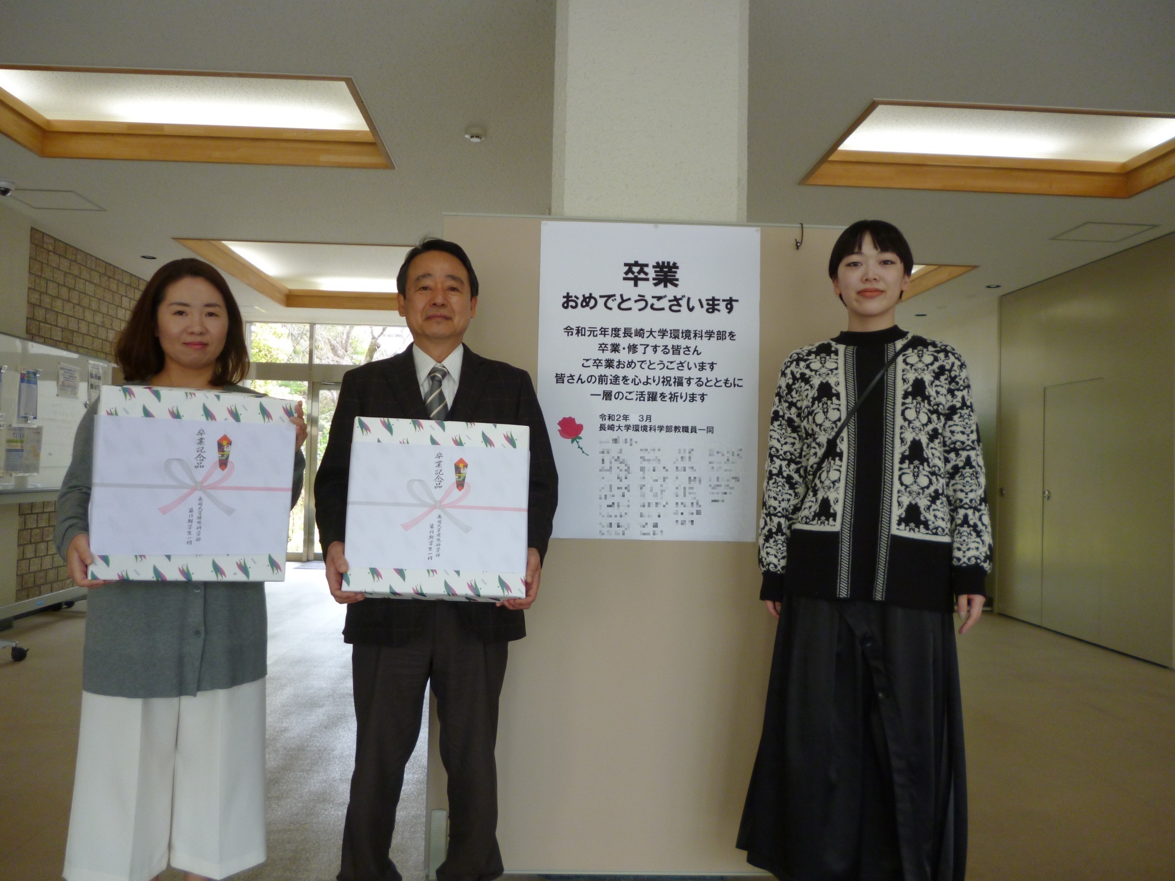 右から卒業生代表の松本佳純さん，山下学部長，学務担当職員