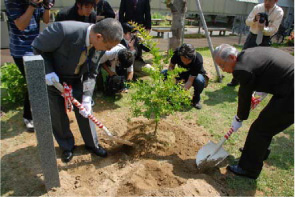 植樹をする齋藤学長(左)と榊氏