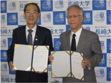 協定書に署名した片峰学長（右） と寺田教育長