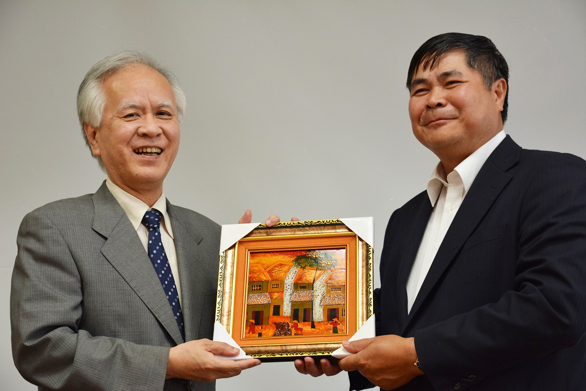 フン駐日ベトナム大使から記念品を受け取る片峰学長