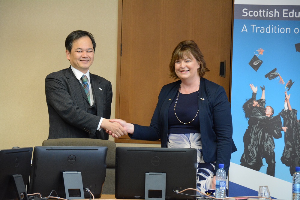 握手を交わす山本郁夫教授（左側）とスコットランド政府フィオナ・ヒスロップ文化・観光・対外 関係大臣（右側）