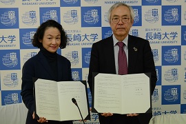 協定書を掲げる日比谷ICU学長と河野学長