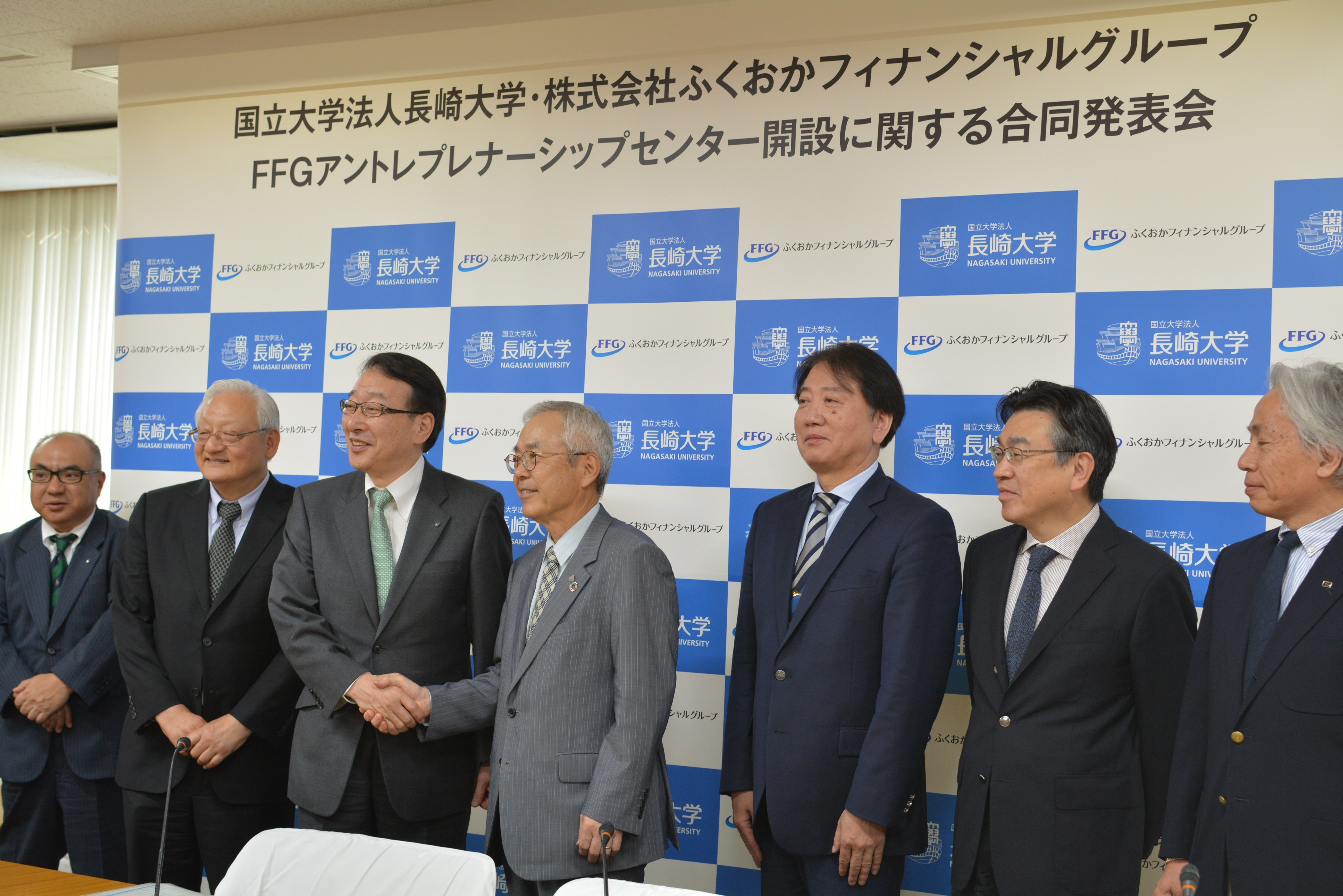 関係者集合写真（左から十八銀行松本常務、親和銀行石丸常務、FFGVBP福田社長、FFG柴戸社長、河野学長、塚元理事、下川理事、赤石副学長）