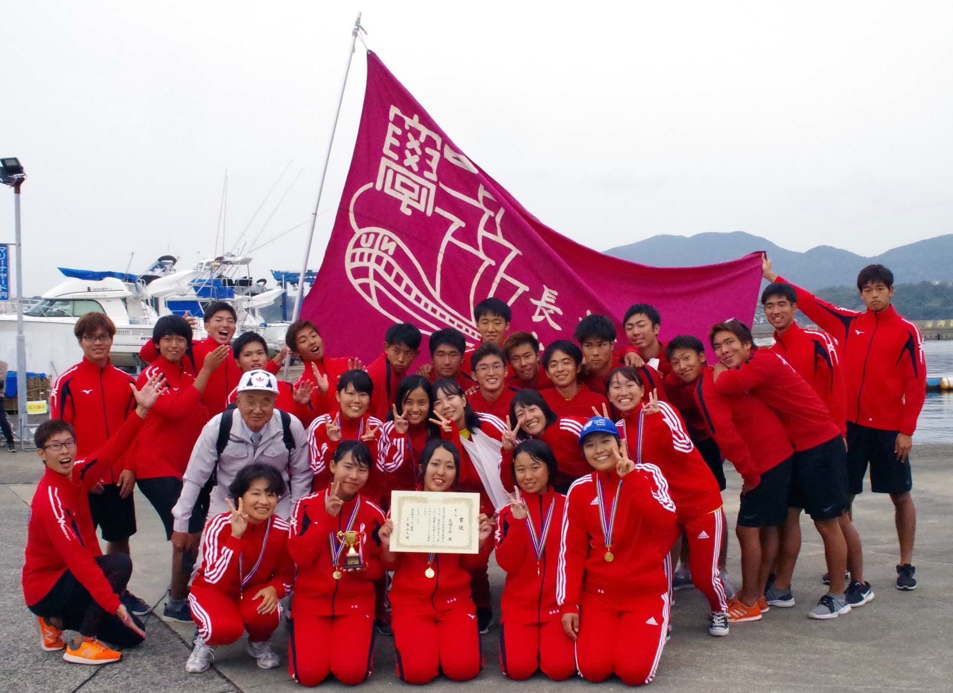 優勝を喜び合う水産学部端艇部員らと高山久明全日本カッター連盟会長（二段目左端）