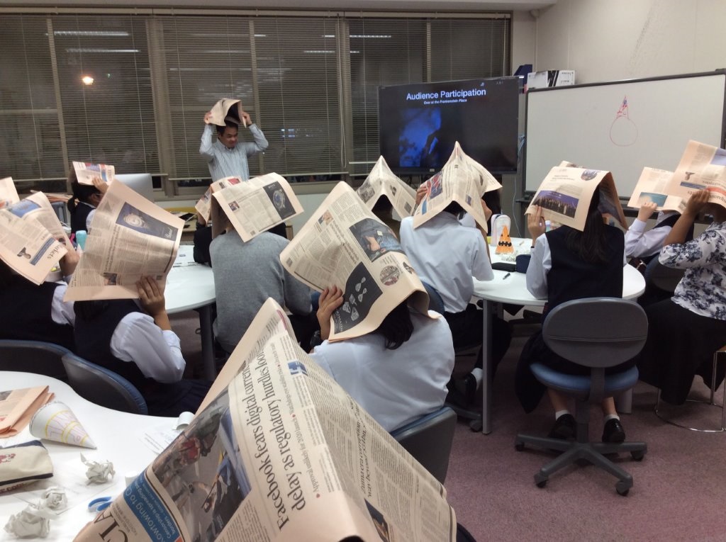 【雨のシーンで新聞紙のハットを被る参加者】