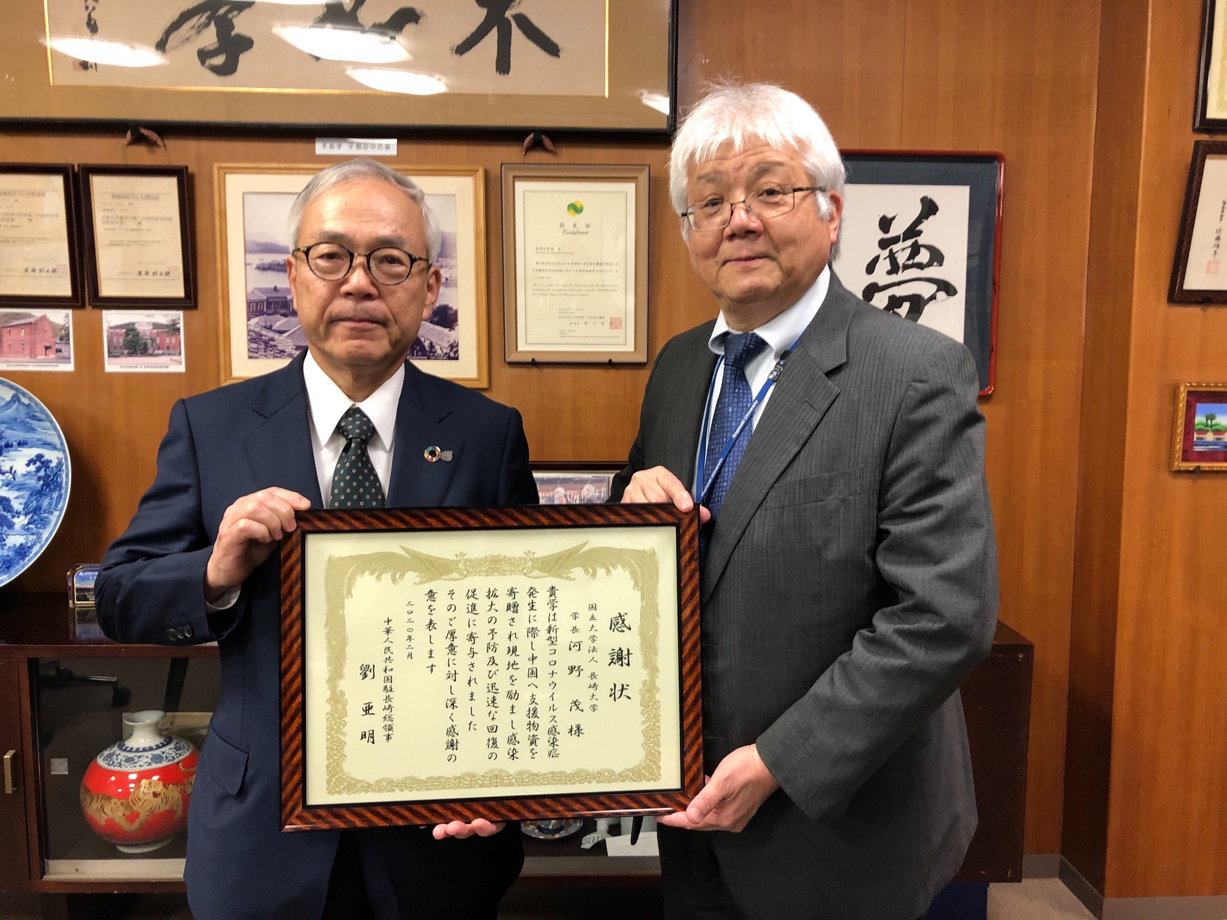 感謝状を掲げる河野学長と夛田副学長