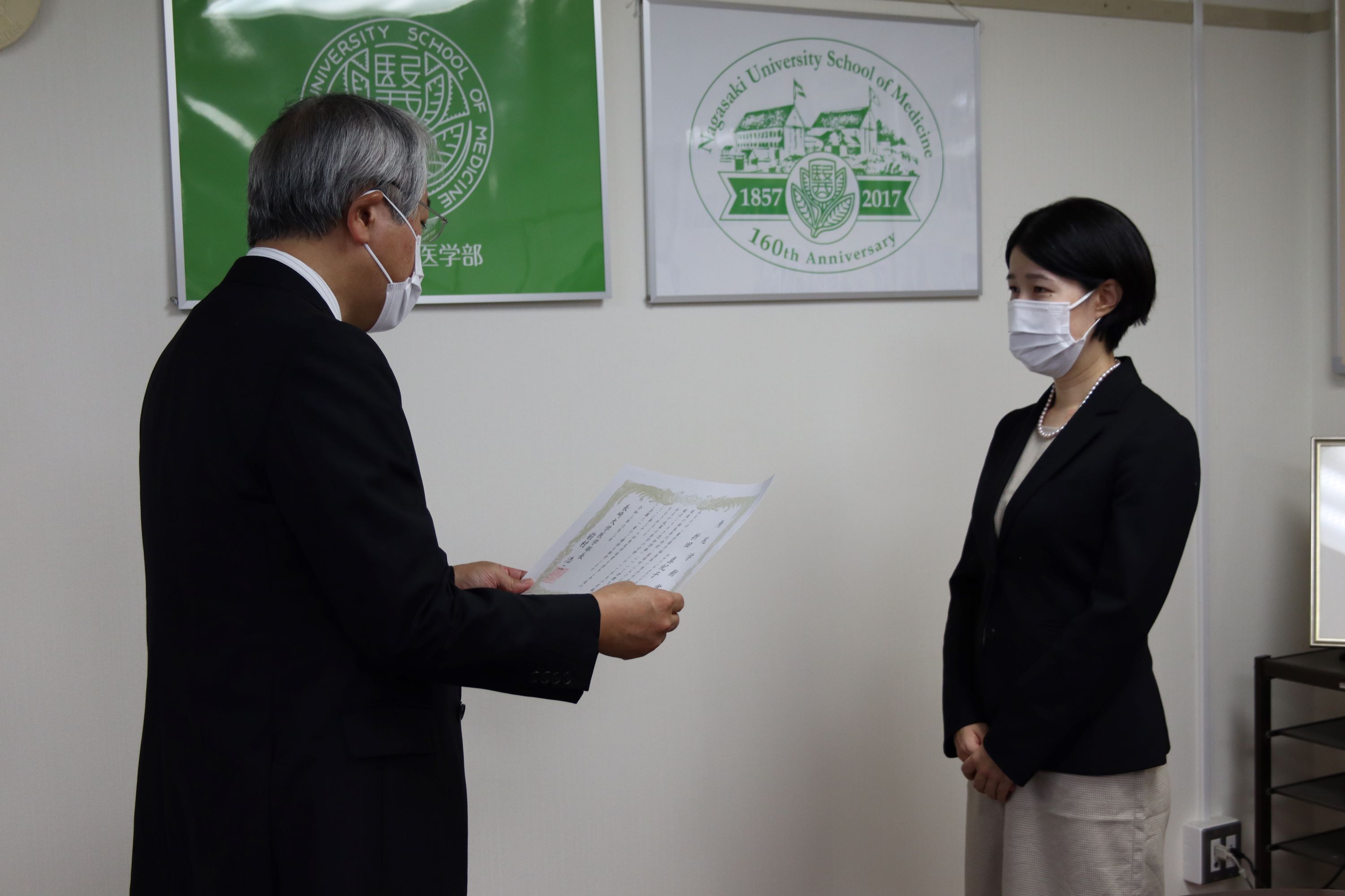 医学部長から表彰状を授与される折田助教